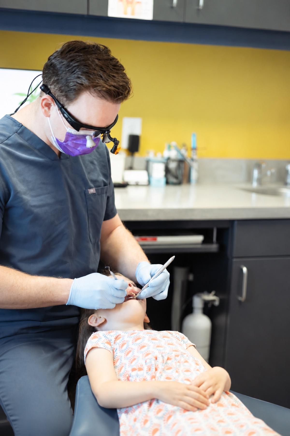 Dr. Mason Welch providing attentive dental care to a young patient at Soft Shores