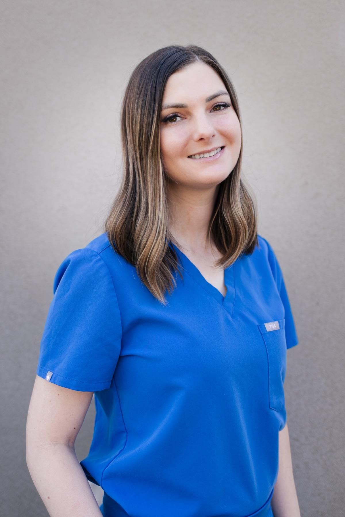 Brittany, Soft Shores lead dental assistant, smiling in blue scrubs